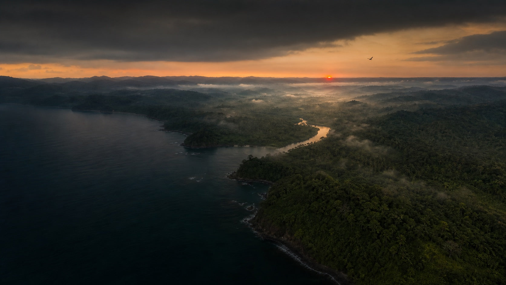 Aerial view across a forested Panamanian coastline at first light